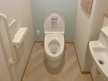 トイレリフォームヘリンボーン柄の床と淡いグリーンが調和するレストルーム