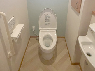 トイレリフォーム ヘリンボーン柄の床と淡いグリーンが調和するレストルーム